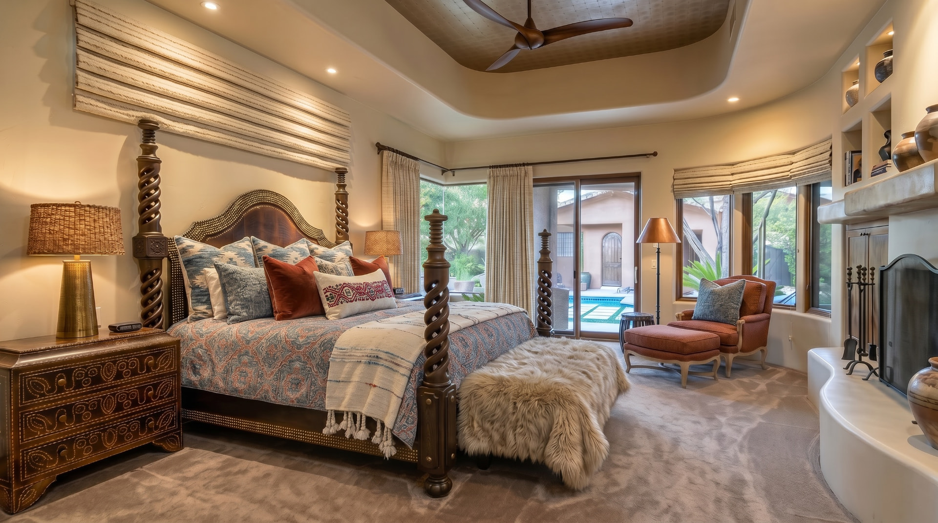Principal bedroom with carved four-poster bed, tray ceiling and desert patio views — desert residence, Scottsdale, Arizona